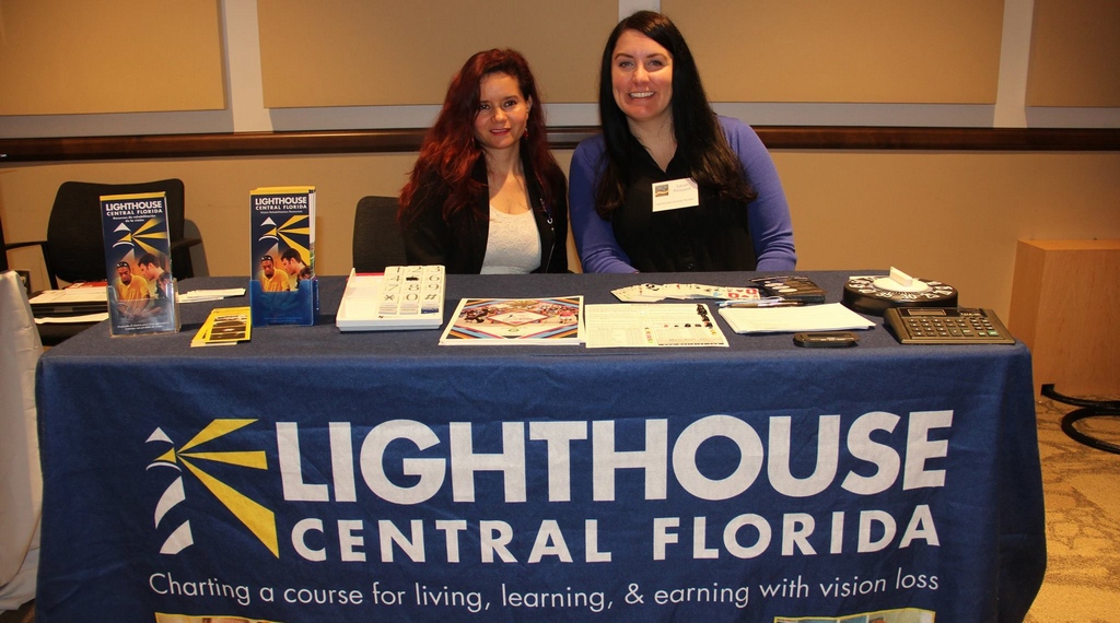 Two women sent at the Lighthouse Central Florida Display table